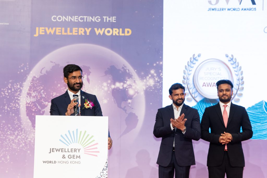 Brijesh Dholakia giving the acceptance speech after receiving the award with Rajesh Dholakia and Hitarthbhai Dholakia during Gem & Jewellery World Hong Kong. 